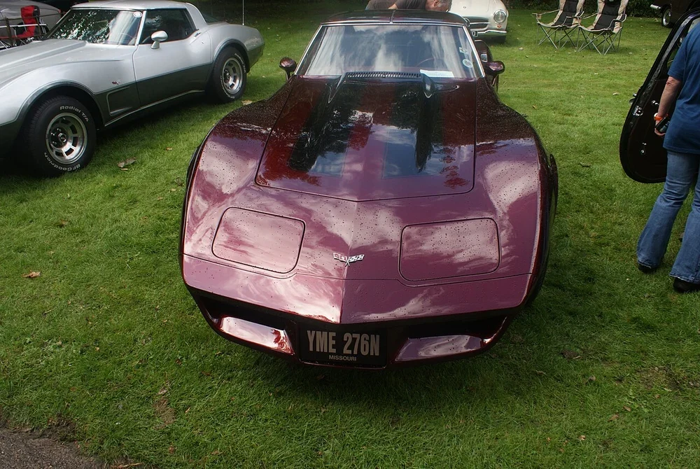 Burgundy classic sports car at an outdoor gathering